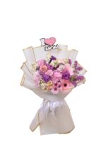 A royal touch bouquet, a luxurious rose arrangement from Gerbera, Pink, Antrina, and Status, in white packaging with gold edges and the phrase "I Love Mom." Suitable for flower delivery in Egypt.